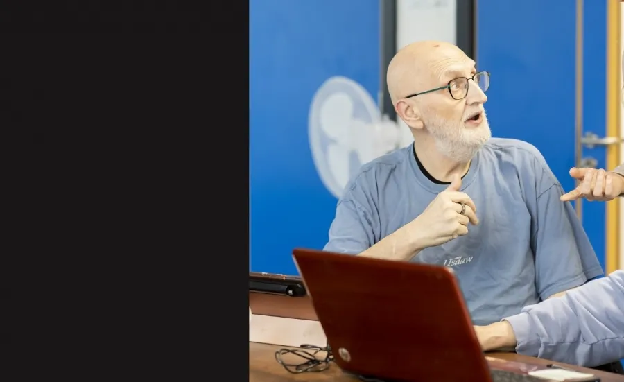 Two elderly men and a woman with laptops